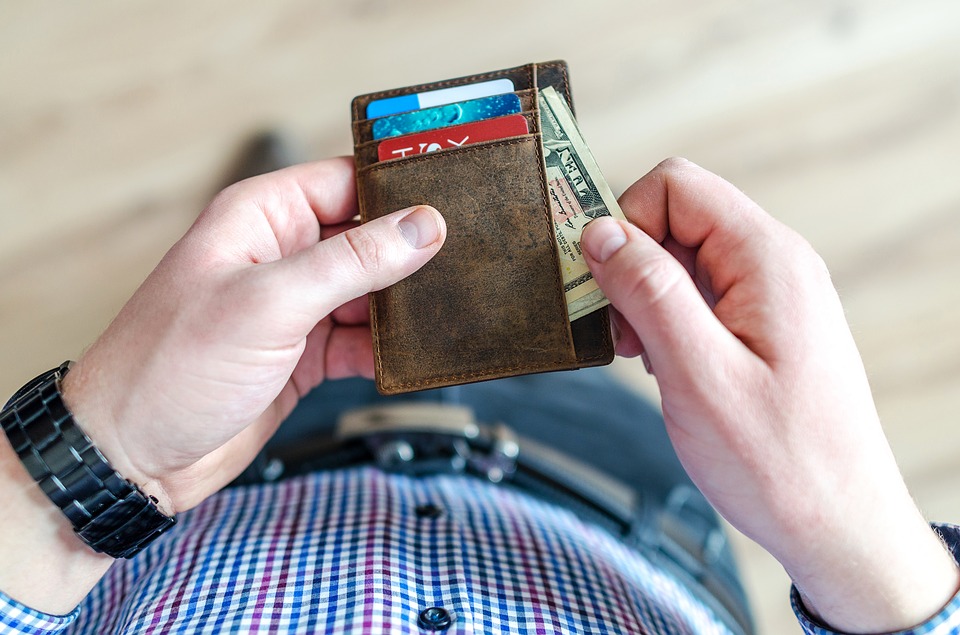 Man looking at his wallet, preparing to pay for moving prices Miami.