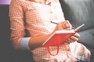 A woman writing in a notebook.