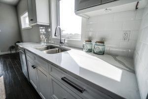 White kitchen with counter top and sink.