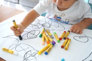 Child drawing with crayons.