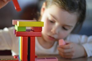 Girl playing with different colored blocks.
