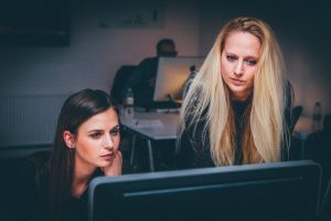 Two women looking at a computer.