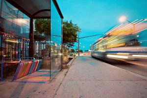bus passing by on glass wall during daytime