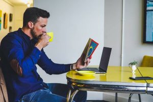 a man reading and sipping coffee before moving to Miami Gardens