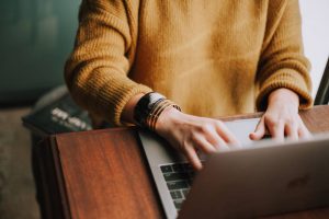 person reading on laptop about how to find reliable moving companies Pompano Beach FL