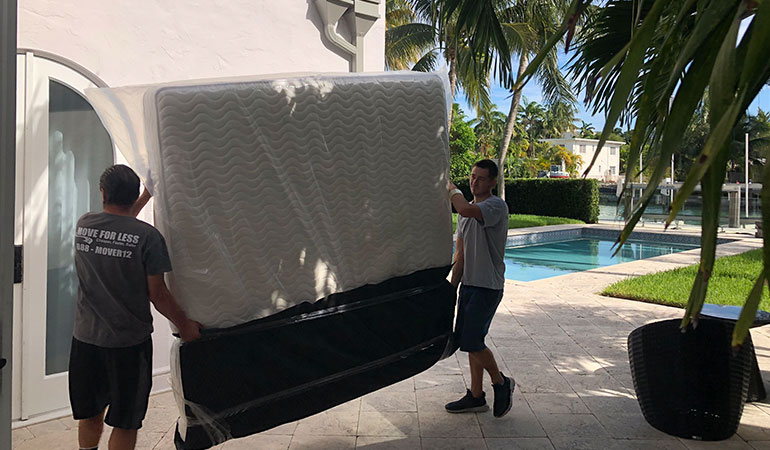 Movers carrying packed furniture.