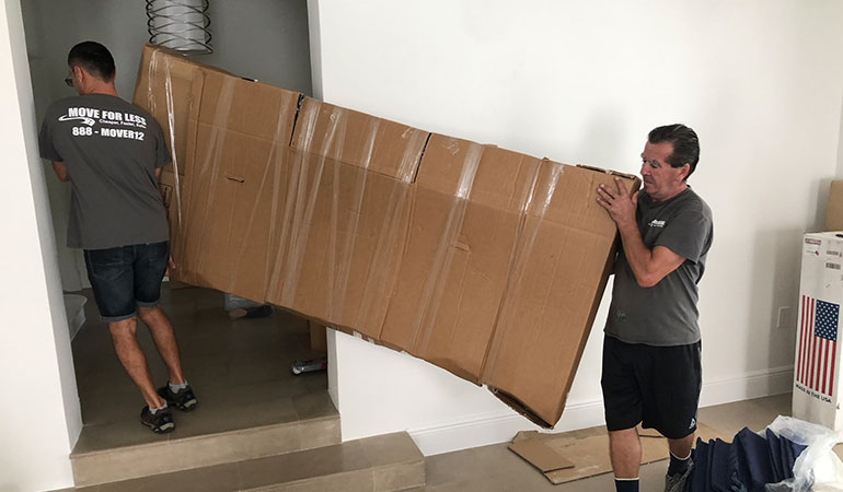 Movers carrying a packed item