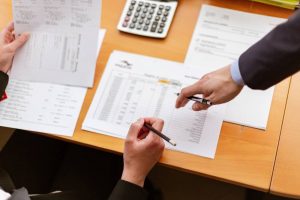 person pointing at papers