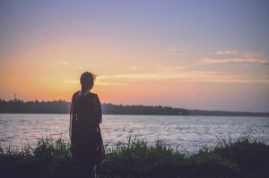 a person on a shore looking at the water