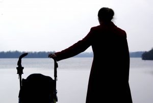 a woman walking a baby near a lake after moving to Fort Lauderdale with a newborn