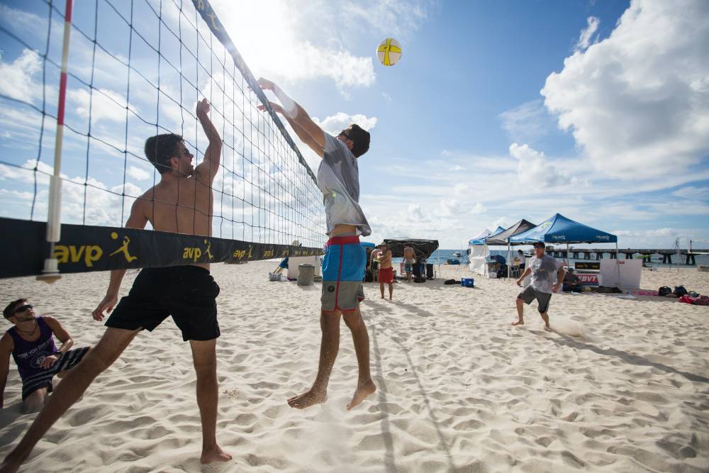 people playing volleyball on the beach