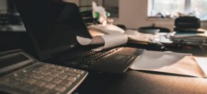 A calculator and a laptop on the table