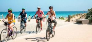 Picture of friends riding bicycles on a beach trying to get to know Boca Raton