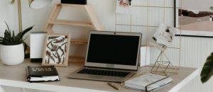 A desk full of planners and a lap top