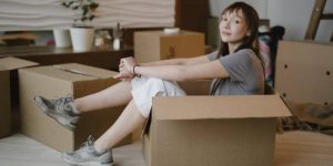 A woman sitting in a moving box