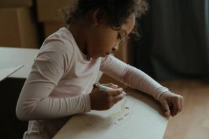A girl inside a moving box drawing