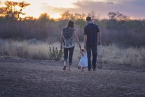 men, woman and a child walking
