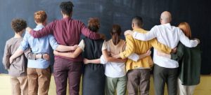 8 people hugging as symbol of cultural diversity and one of the reasons why you should move to Miami from Fort Lauderdale