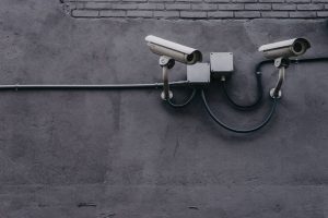 two security cameras on a gray wall
