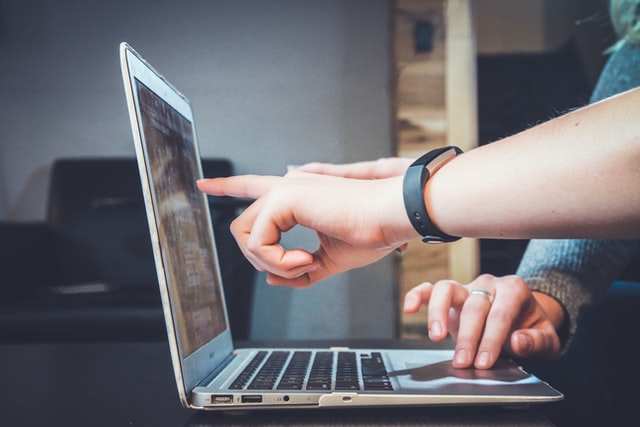 a man pointing a finger to laptop