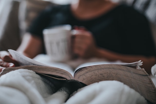 a person reading a book while trying to balance moving with work