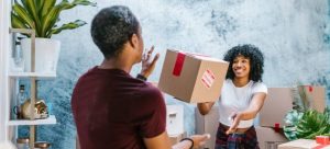 A millennial couple stacking boxes for their long-distance move