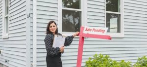a real estate agent in front of a house while trying to find an affordable home in Miami
