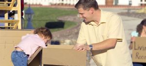 father and daughter helping their neighbors move