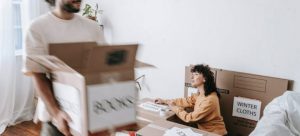A man and a woman labeling their moving boxes thinking about keeping important documents secure
