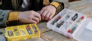 Fishing hooks in tiny boxes on a wooden table