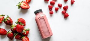 a pink smoothie and strawberries as an example of how to prepare meals for long distance move
