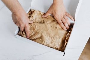 A person packing something in a white box