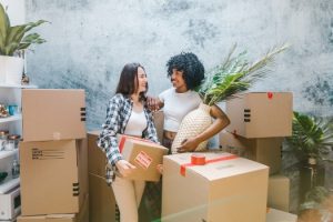 two girls holding moving boxes