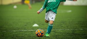 child kicking ball
