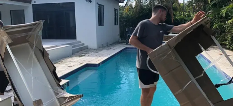 two people carrying furniture