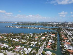 A person thinking about places to live in Miami Dade County while looking at aerial photo of city buildings