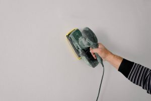 A repairman polishing the wall