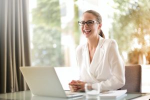 Laughing businesswoman thinking about how to find a job in Coral Gables.