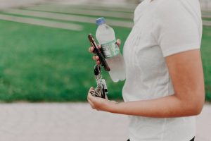 A person holding bottled water and keys