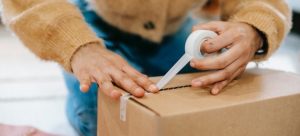 woman taping the box to get through first move in Miami