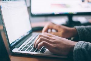 a person researching what to do when relocating to a different climate on a laptop