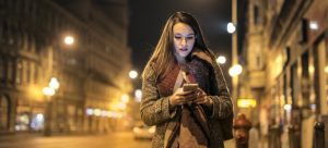 a girl walking home at night and reading about the most common questions about moving to Miami