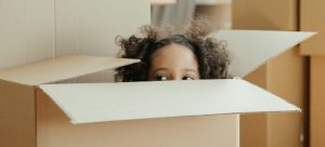 Girl sitting in a box during a family relocation from Davie to Pembroke Pines