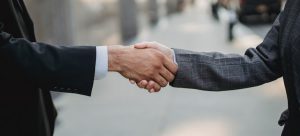 two men shaking hands to expand family business to Miami in 2022