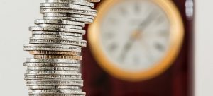 coins on the top of each other and a clock