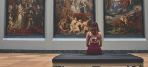 a girl inspecting paintings in a museum in one of the most popular places in Florida for artists