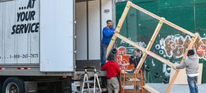 Four people load a moving truck