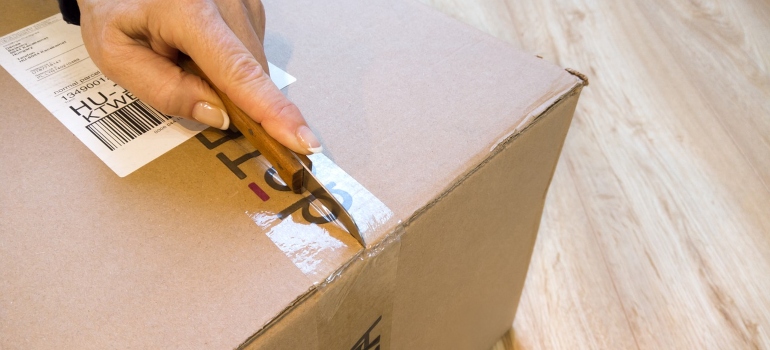 a man unpacking a box using a knife