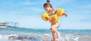 a small child on the beach jumping in the water