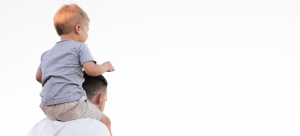 a man holding a child on their shoulders
